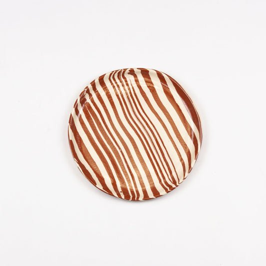 Round cushion with brown and beige striped pattern on a white background