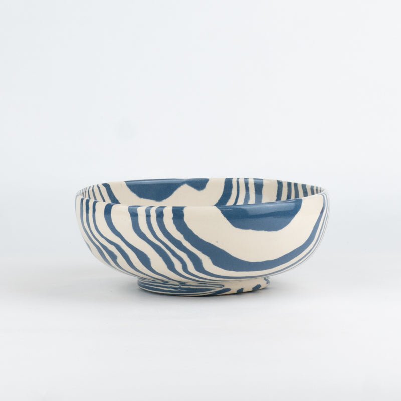 Ceramic bowl with blue and white abstract pattern on a white background